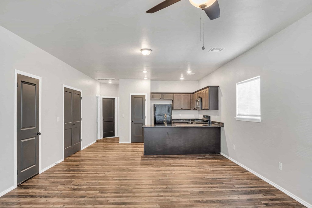 a kitchen with a counter and a refrigerator in a room with a living room
