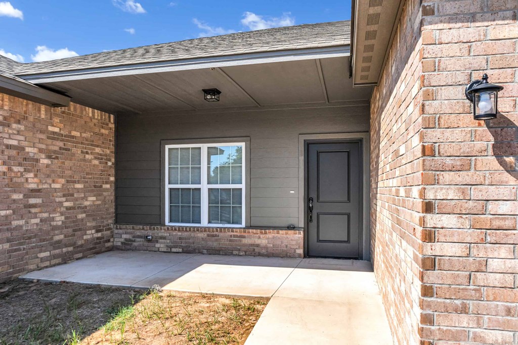 the front door of a brick house with a porch