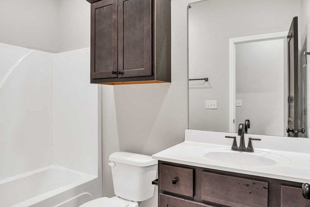a bathroom with a sink toilet and a mirror