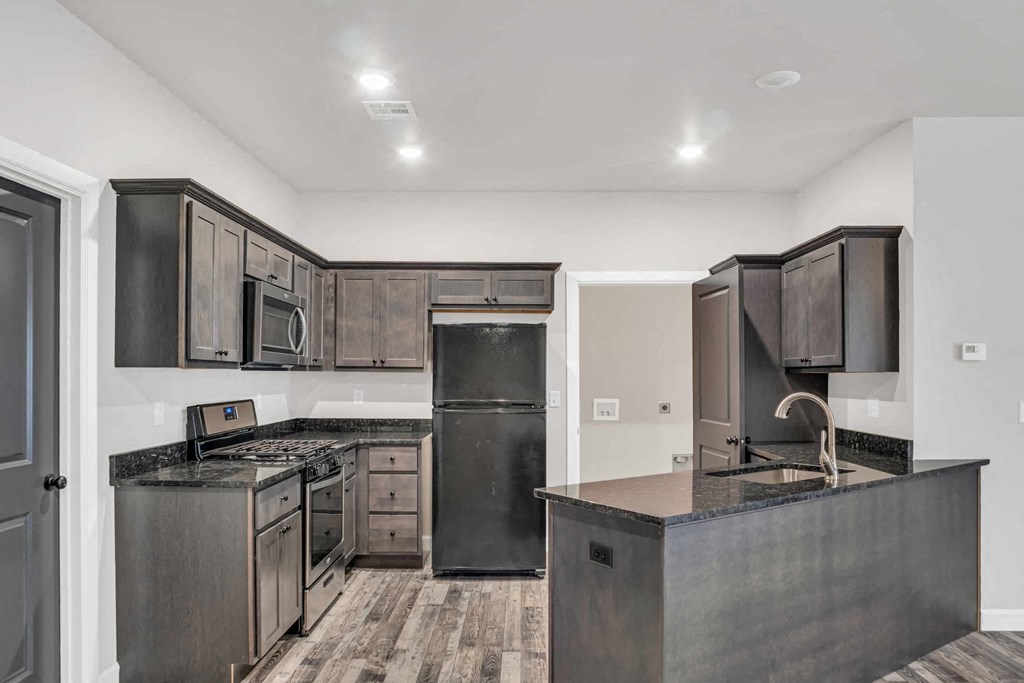 a kitchen with stainless steel appliances and dark wood cabinets