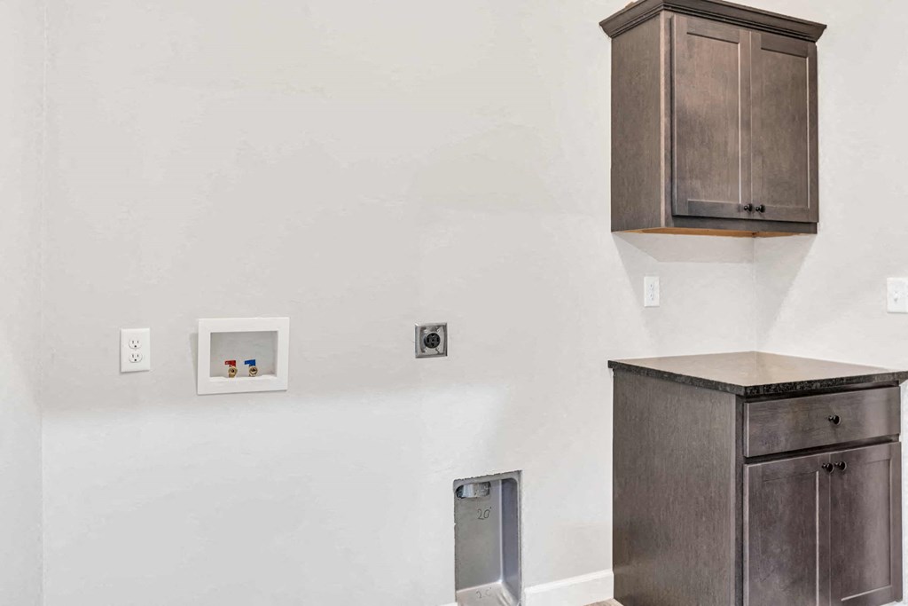 a kitchen with wooden cabinets and a white wall with outlets