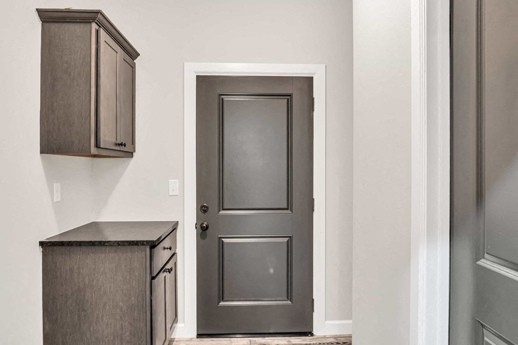 a gray door in a kitchen with dark cabinets