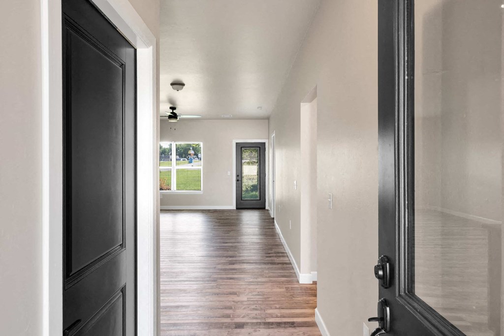 a view of a hallway from a house with a black door