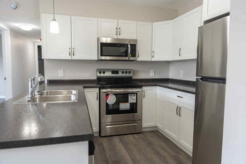 a kitchen with stainless steel appliances and white cabinets