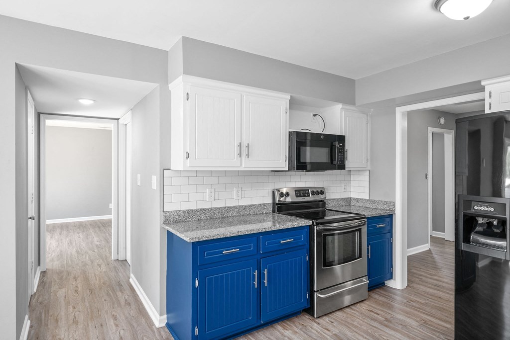 a renovated kitchen with blue cabinets and stainless steel appliances