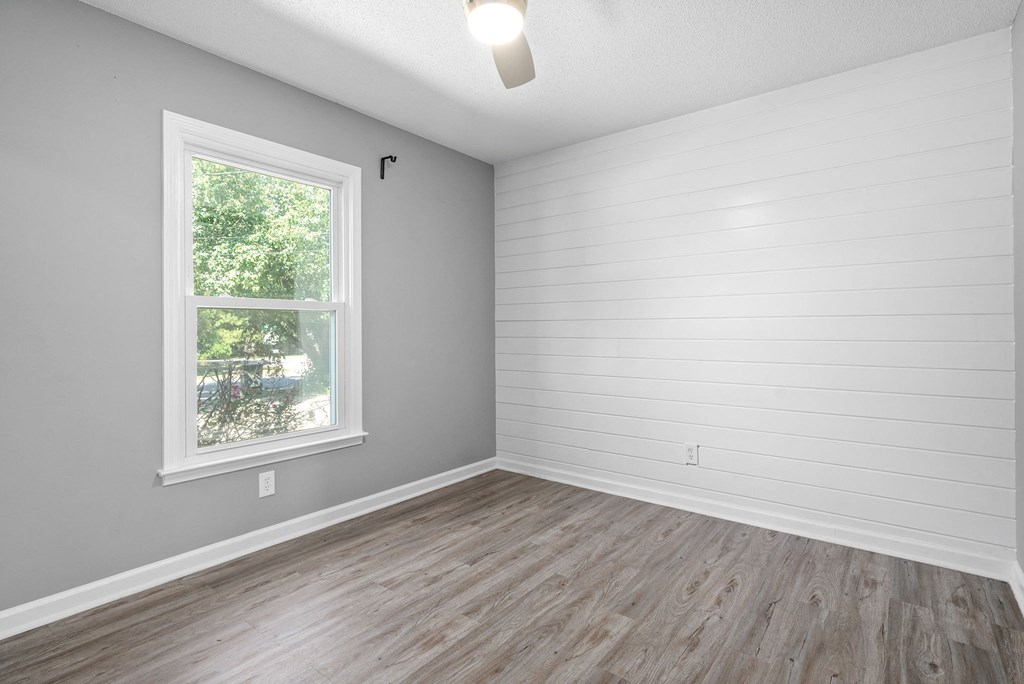 an empty room with wood floors and a window