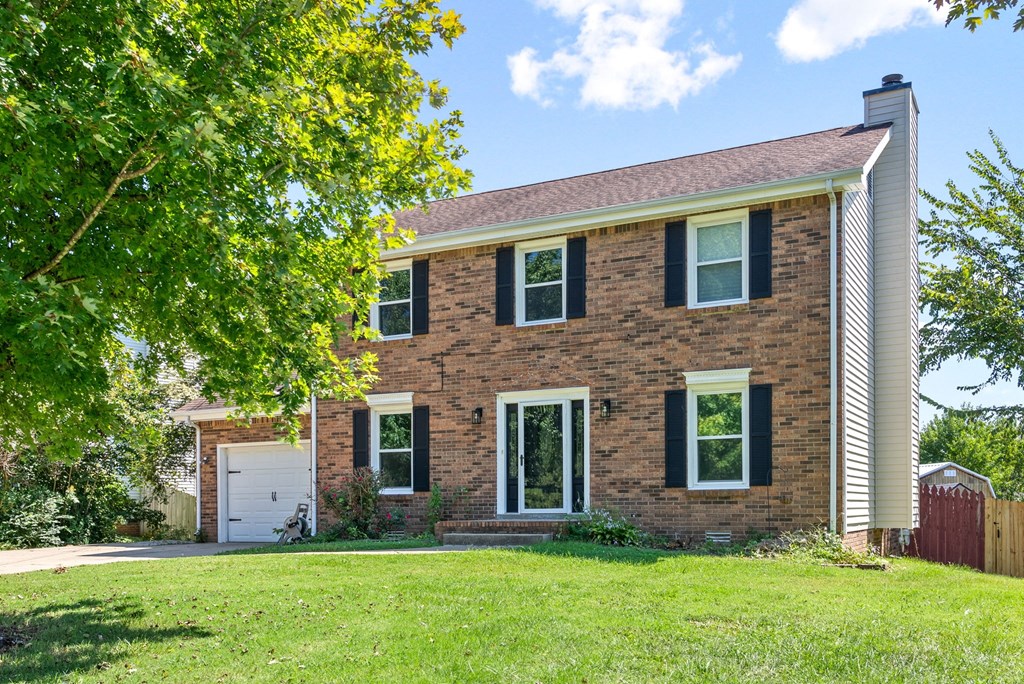a brick house with a lawn in front of it