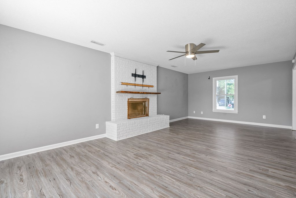 a living room with a fireplace and a ceiling fan