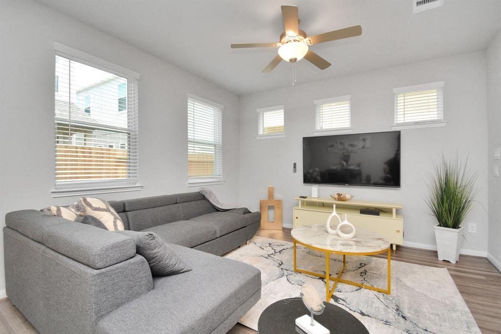 a living room with a couch and a ceiling fan