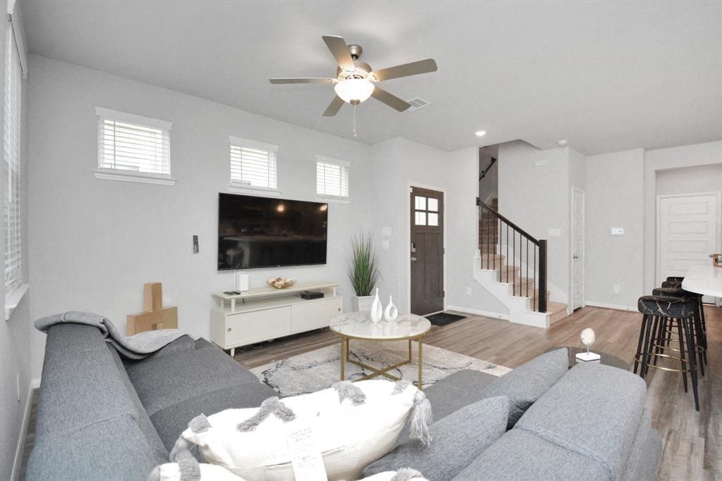 a living room with a couch and a ceiling fan