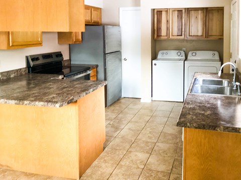 A kitchen with a black countertop and a sink.