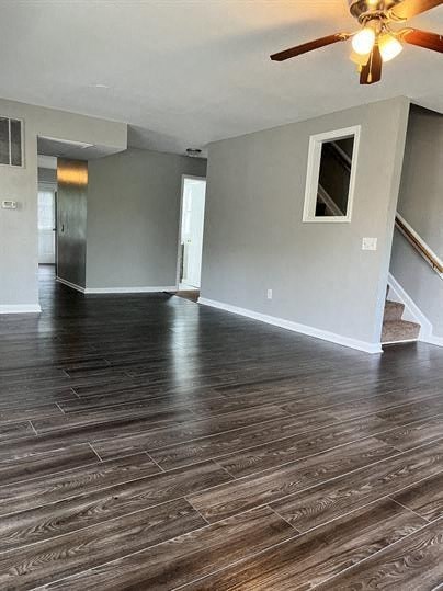 a empty living room with a ceiling fan