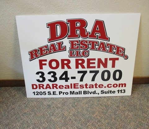 A sign advertising a real estate company for rent.