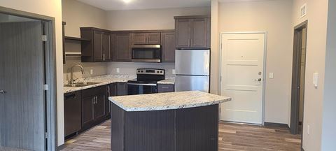 a kitchen with dark cabinets and a granite counter top