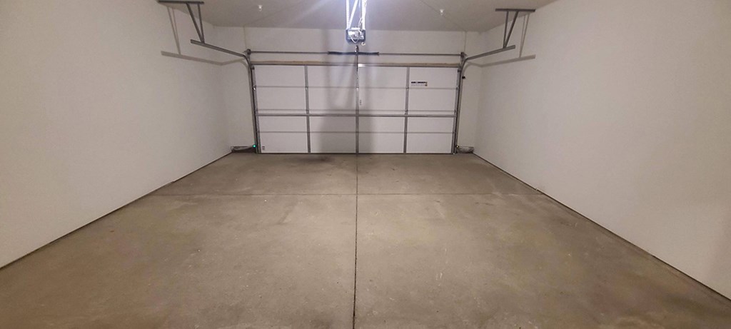 a empty garage with a cement floor and white walls