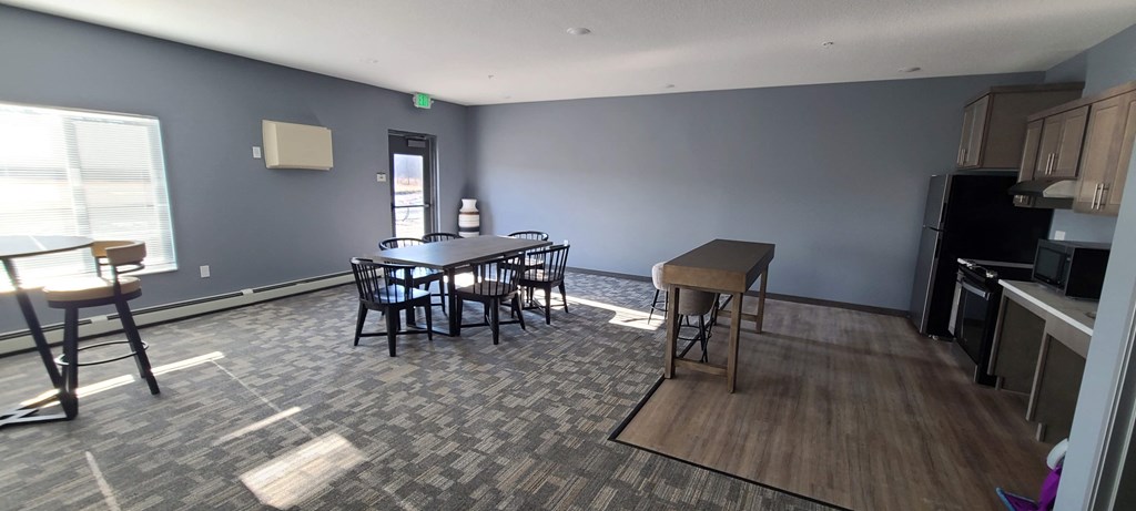 a dining room with a table and chairs and a kitchen