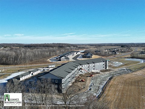 an aerial view of a building with a hangar and a building under construction