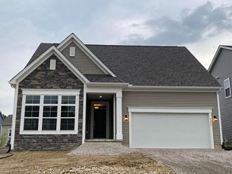 a home with a gray roof and a white garage door