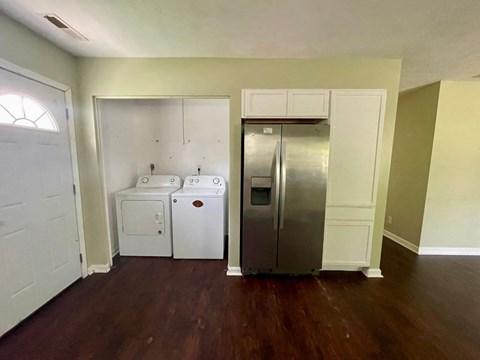 A kitchen with a white door, a white dishwasher, and a silver refrigerator.