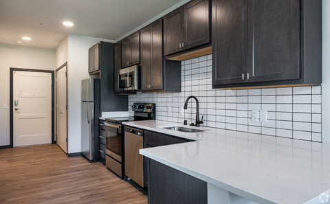 a kitchen with a white counter top and black cabinets