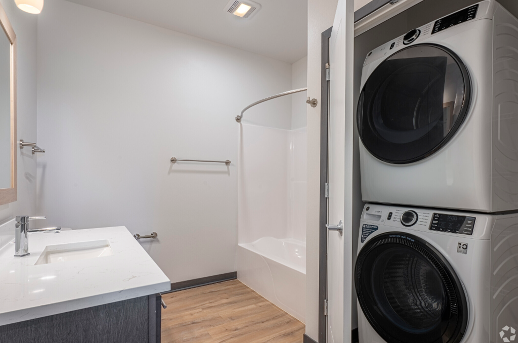 a washer and dryer in a bathroom with a sink and a shower