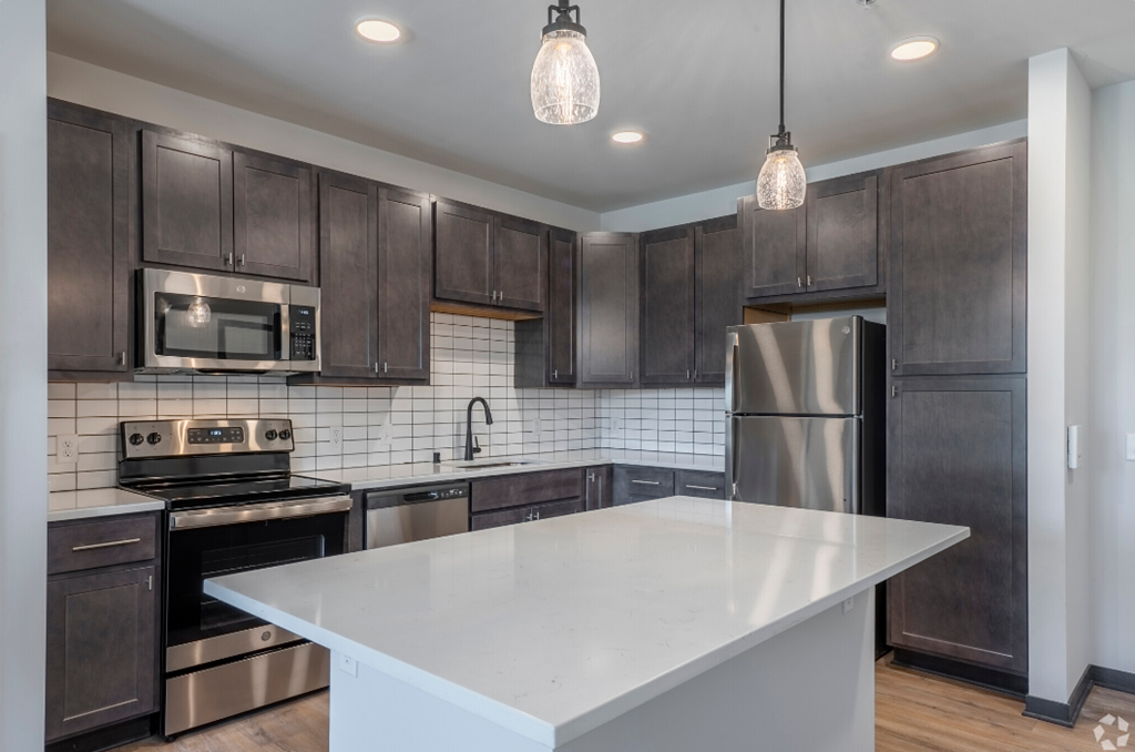 a kitchen with stainless steel appliances and a white counter top