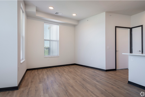 an empty living room with white walls and wood flooring