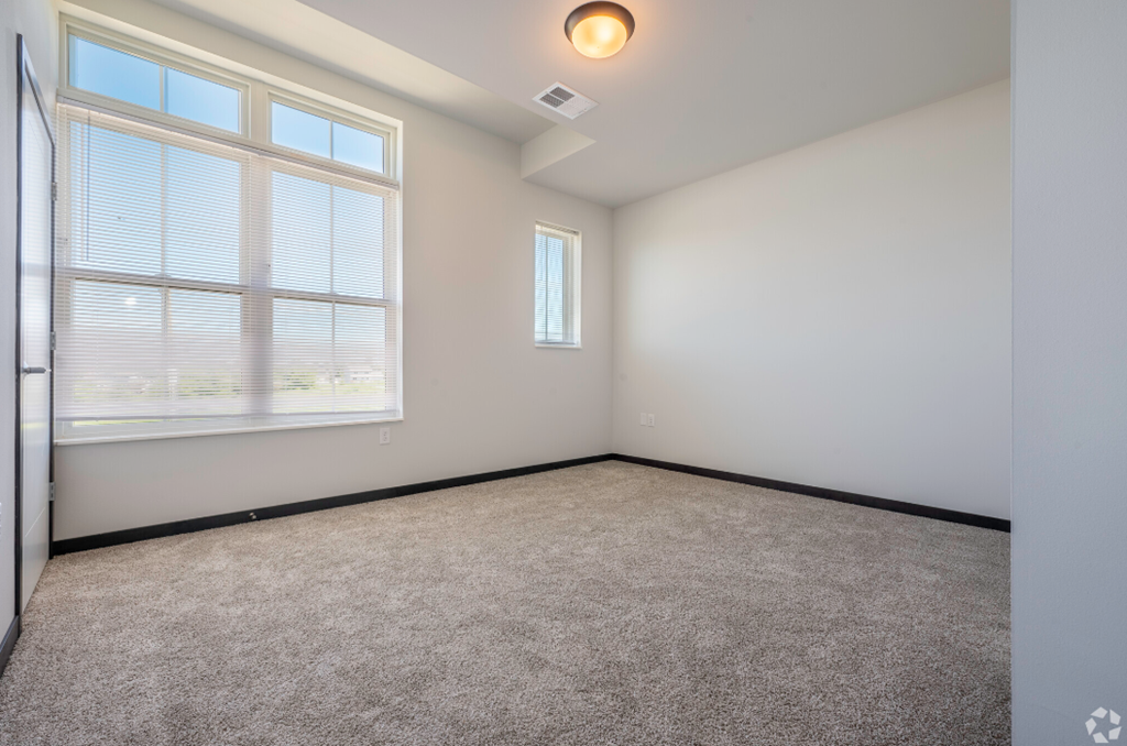 an empty room with carpet and a large window