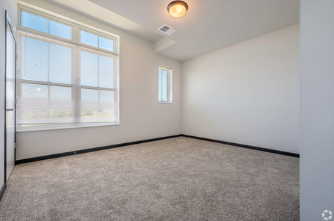 an empty room with carpet and a large window