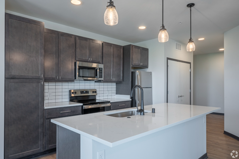 an empty kitchen with a white counter top