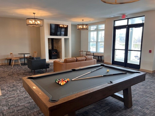a living room with a pool table and couches