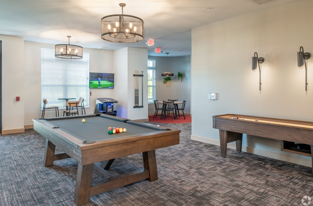 a community room with two billiards tables and a pool table