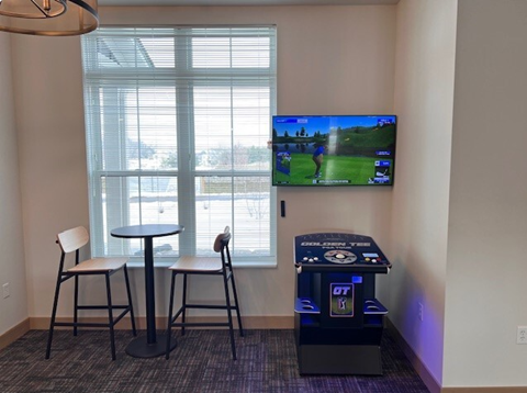a room with a tv and a table with chairs and a gambling machine
