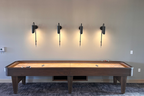 a pool table in a room with lights on the wall