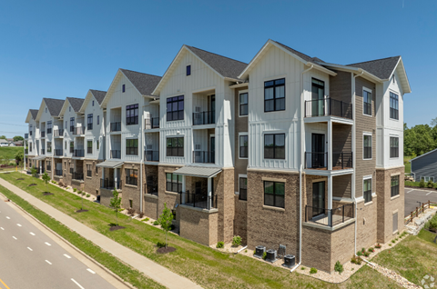 an aerial view of an apartment building on the side of a road