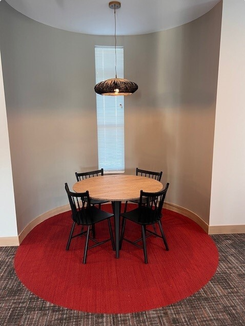 a dining room with a wooden table and black chairs