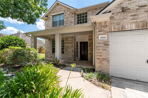 A house with a white garage door and a brick facade.