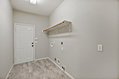A white door is in a room with a shelf above it.