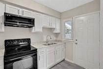a kitchen with a sink and an oven and a door