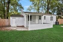 a small white house in a backyard with a lawn