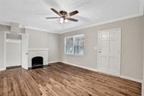an empty living room with a ceiling fan and a fireplace