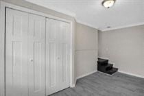 a white room with white closet doors and a staircase