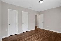 an empty living room with white walls and a wooden floor