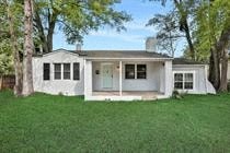 a white house with a lawn and trees