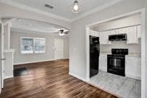 an empty living room with a fireplace and a hard wood floor