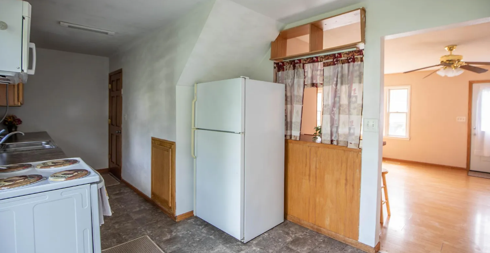 A kitchen with a white refrigerator and a wooden counter.