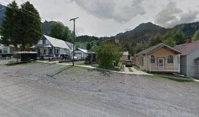 A parking lot with a house and a mountain in the background.