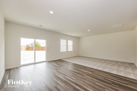 an empty living room with wood floors and white walls