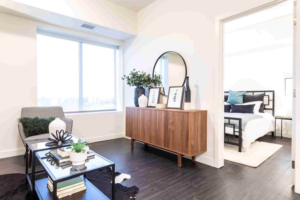 a living room with a dresser and a bedroom with a bed