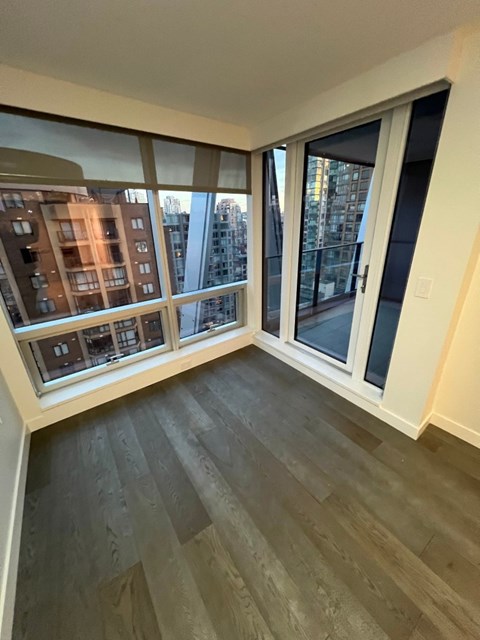 A room with a view of a cityscape through large windows.
